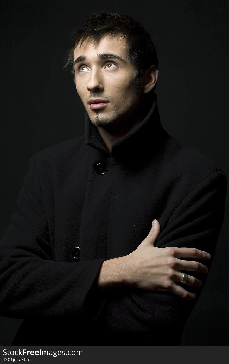 Portrait of a young business man with his hands on a dark background. Portrait of a young business man with his hands on a dark background