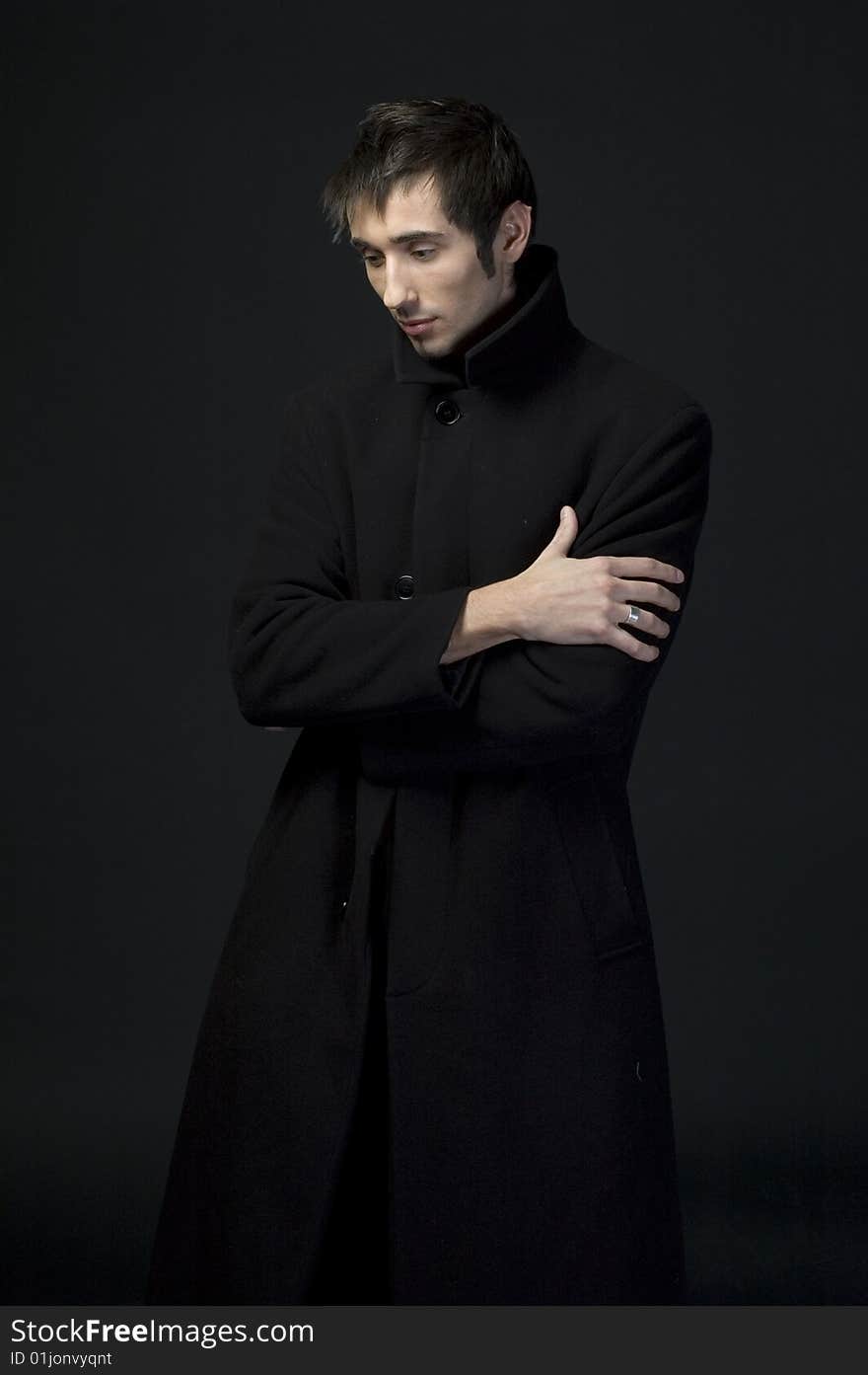 Portrait of a young business man with his hands on a dark background. Portrait of a young business man with his hands on a dark background