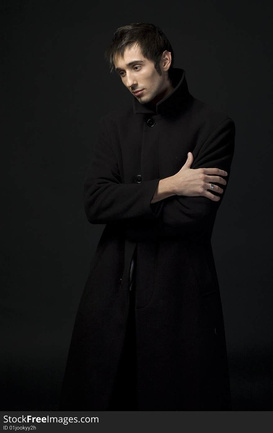 Portrait of a young business man with his hands on a dark background. Portrait of a young business man with his hands on a dark background