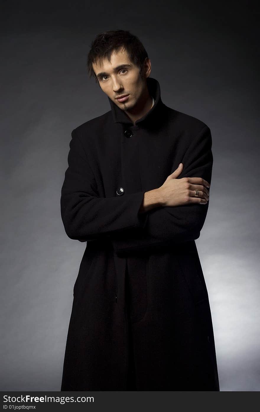 Portrait of a young business man with his hands on a dark background. Portrait of a young business man with his hands on a dark background