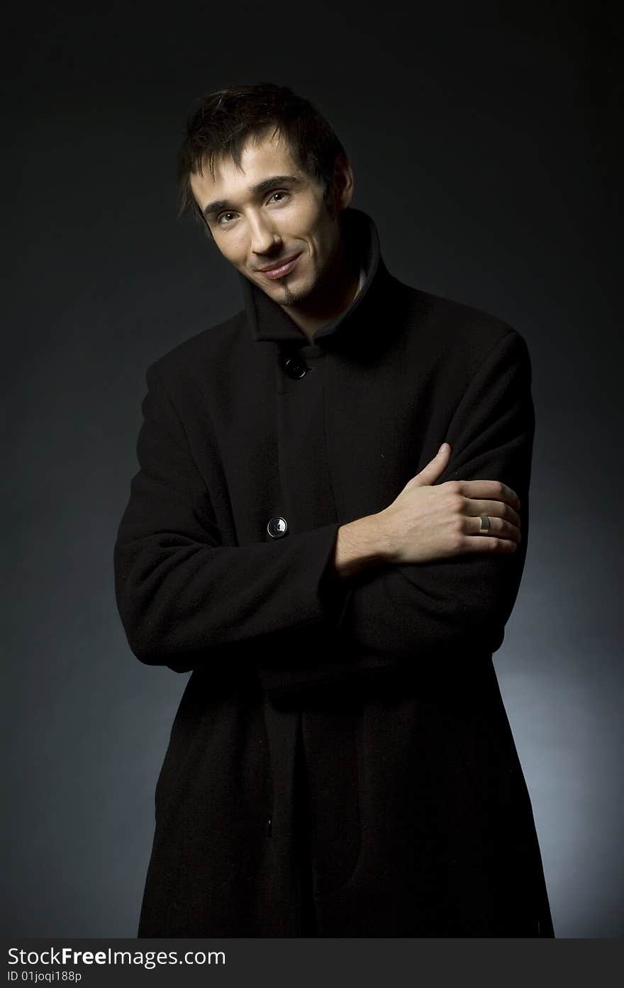 Portrait of a young business man with his hands on a dark background. Portrait of a young business man with his hands on a dark background