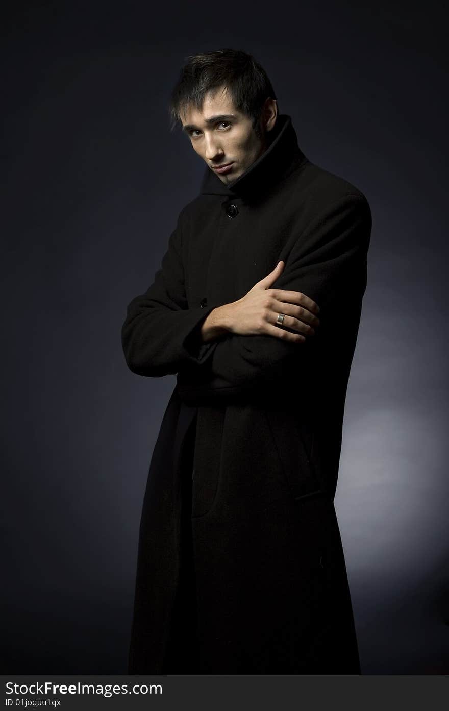 Portrait of a young business man with his hands on a dark background. Portrait of a young business man with his hands on a dark background