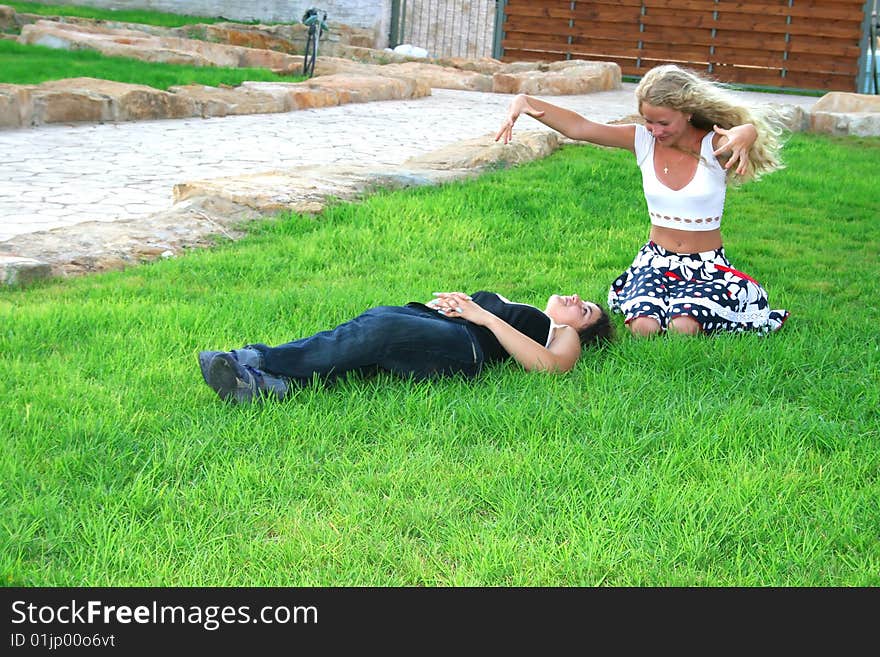 Blond and brunette girls having fun on the grass.