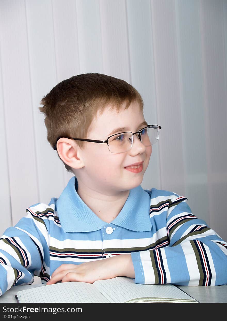 The little boy doing homework on the table. The little boy doing homework on the table