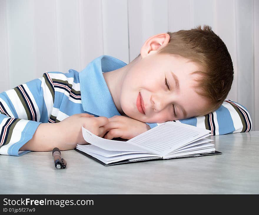 The boy sleeps on a table