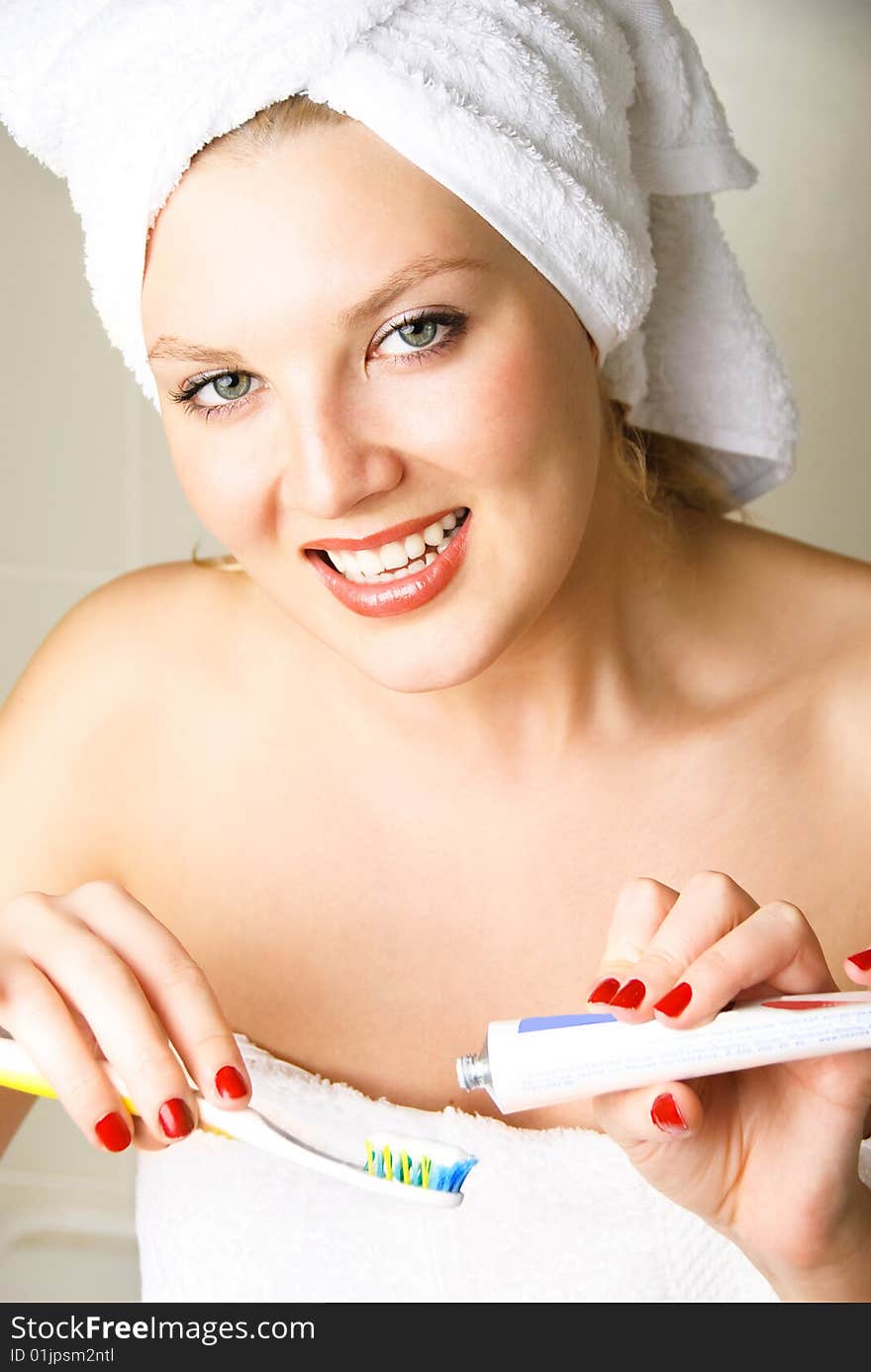 Beautiful young happy woman brushing her teeth in the bathroom. Beautiful young happy woman brushing her teeth in the bathroom