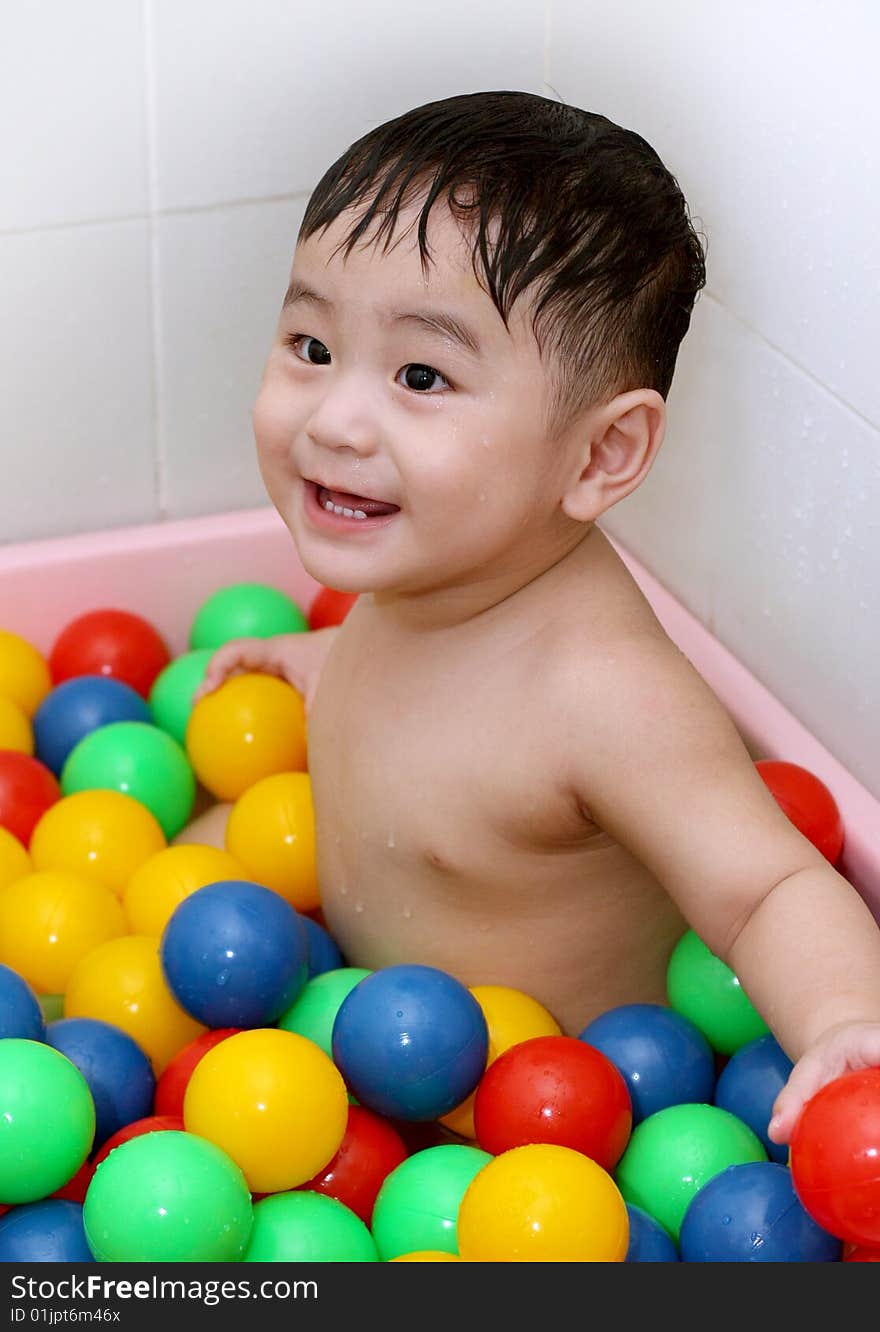 A baby is playing colorful balls. A baby is playing colorful balls