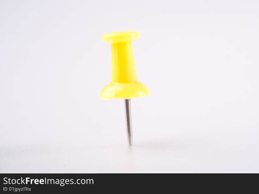 Yellow single pin in white board isolated