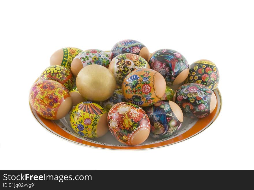 The easter decorated eggs lying in white porcelain plate with a red ornament