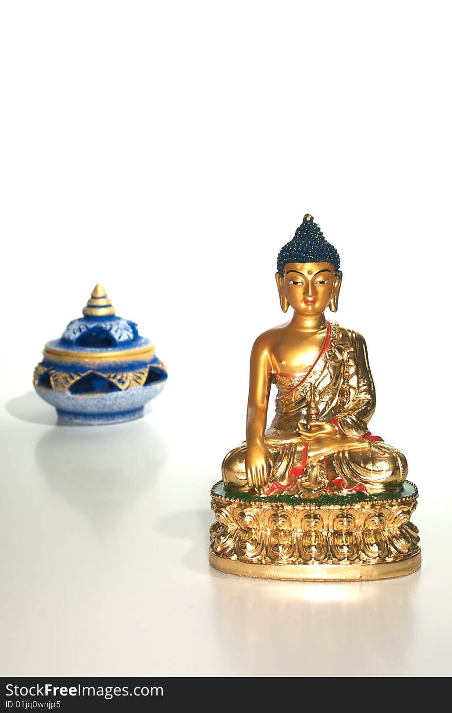 Small statue of a golden buddha isolated on white with an incense burner