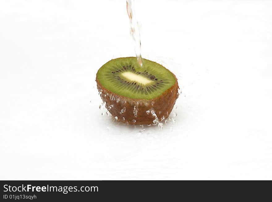 Half of shaggy,juicy  kiwi in streaming water.