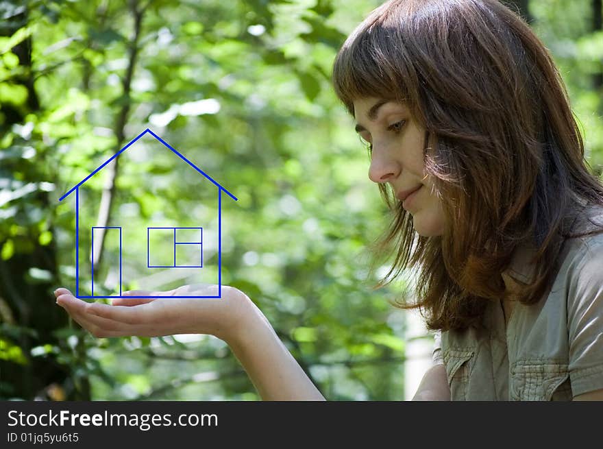 The girl holds the dream house on a palm. The girl holds the dream house on a palm