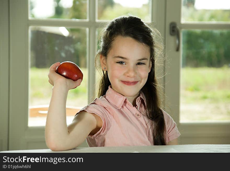 Brown haired child holding an apple. Healthy lifstyle image. Brown haired child holding an apple. Healthy lifstyle image.