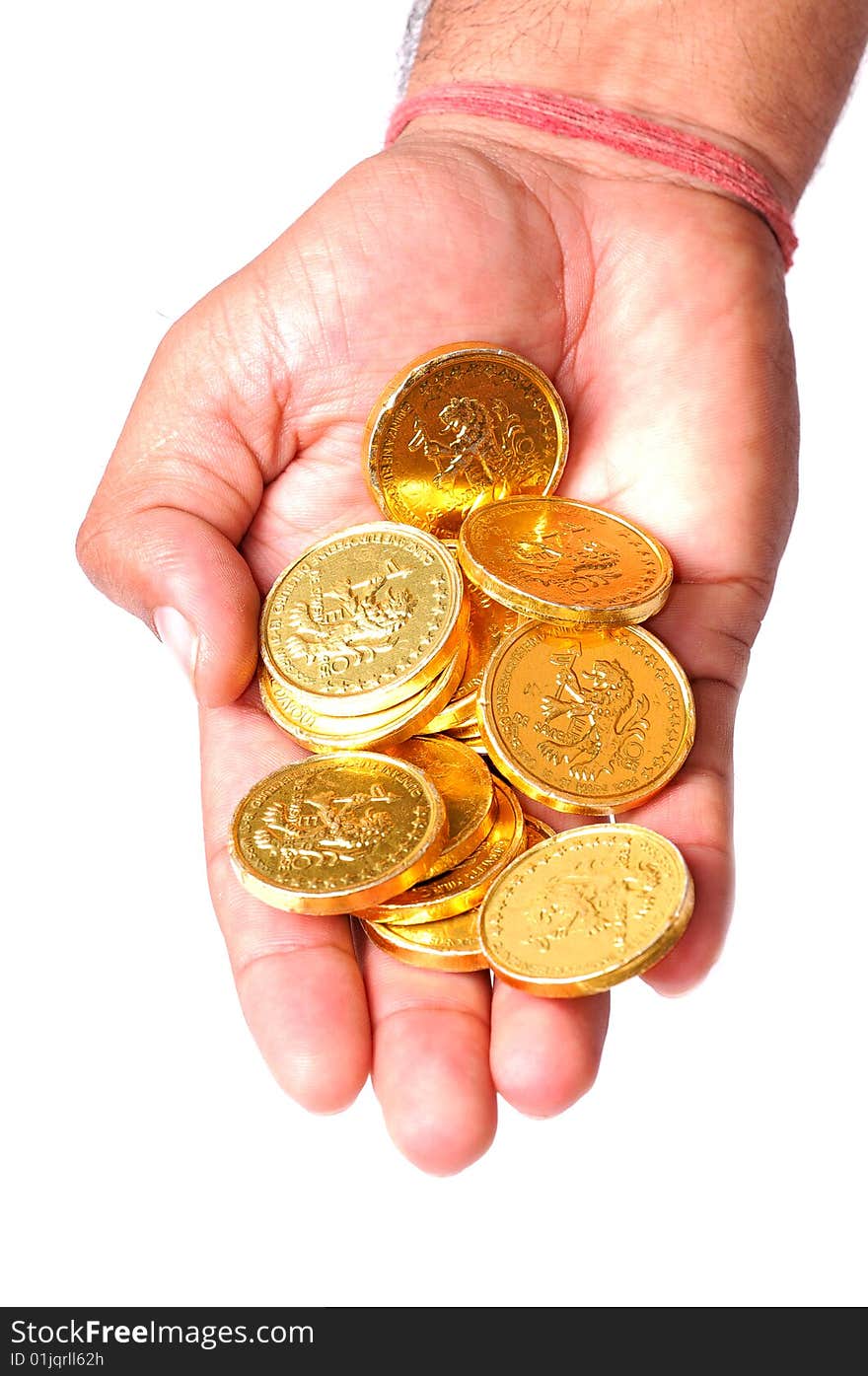 Hand holding gold coins over white background.