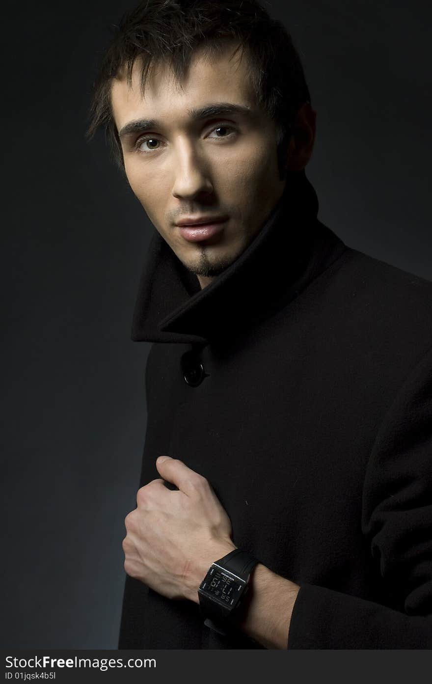 Portrait of a young business man with his hands on a dark background. Portrait of a young business man with his hands on a dark background