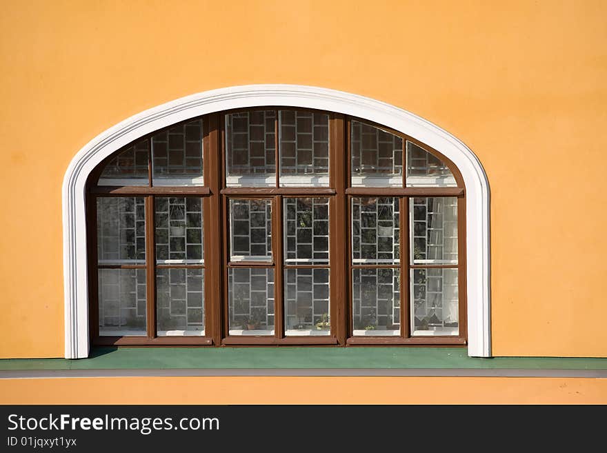 Window with grid in old yellow wall