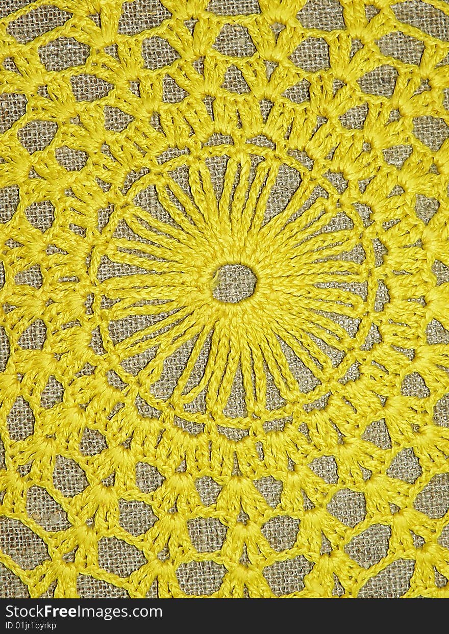 Crochet yellow doily on the linen background. Crochet yellow doily on the linen background