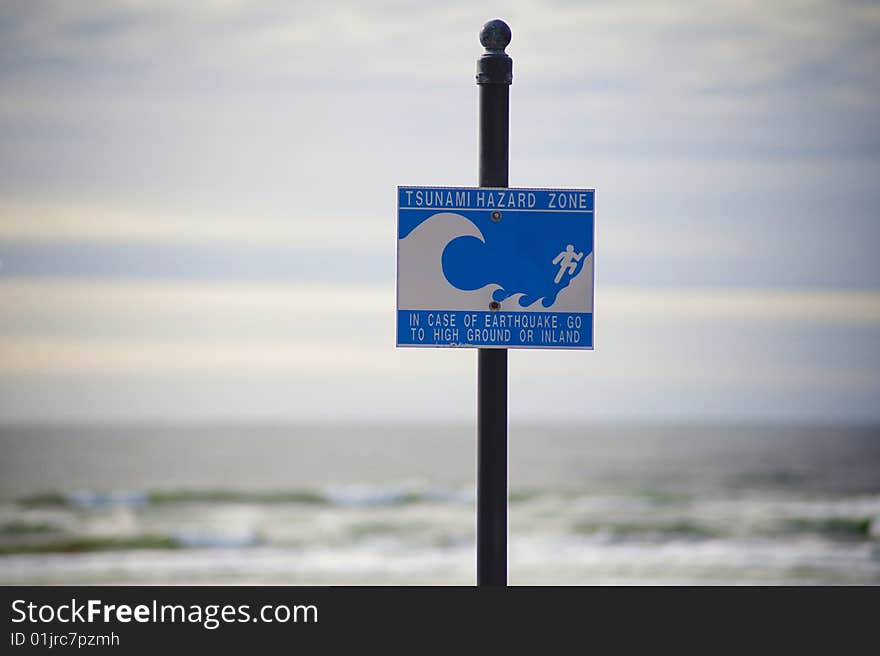 Sign posted at a beach warning of tsunamis. Sign posted at a beach warning of tsunamis