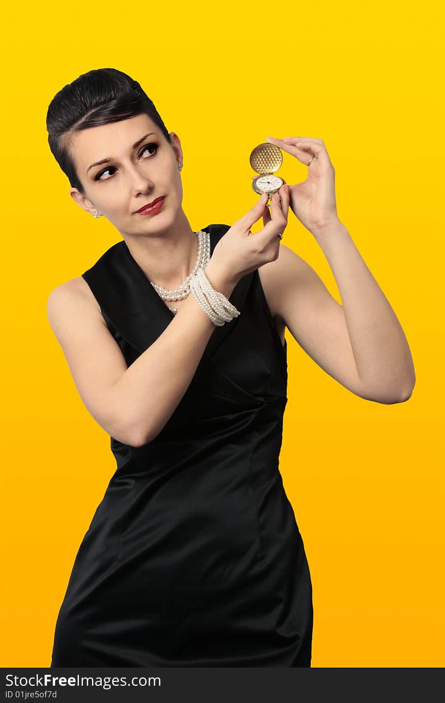 Time for a change. Audrey Hepburn alike holding a classic golden watch looking at copy space isolated on white background