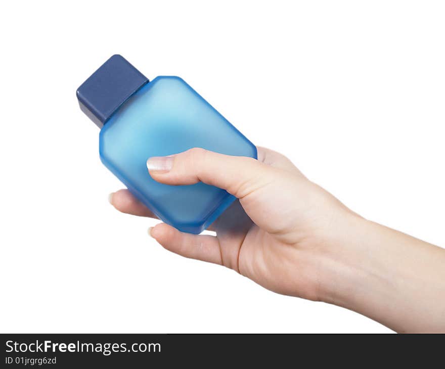 The female hand holds on an open palm a small bottle with perfumery on a white background. The female hand holds on an open palm a small bottle with perfumery on a white background