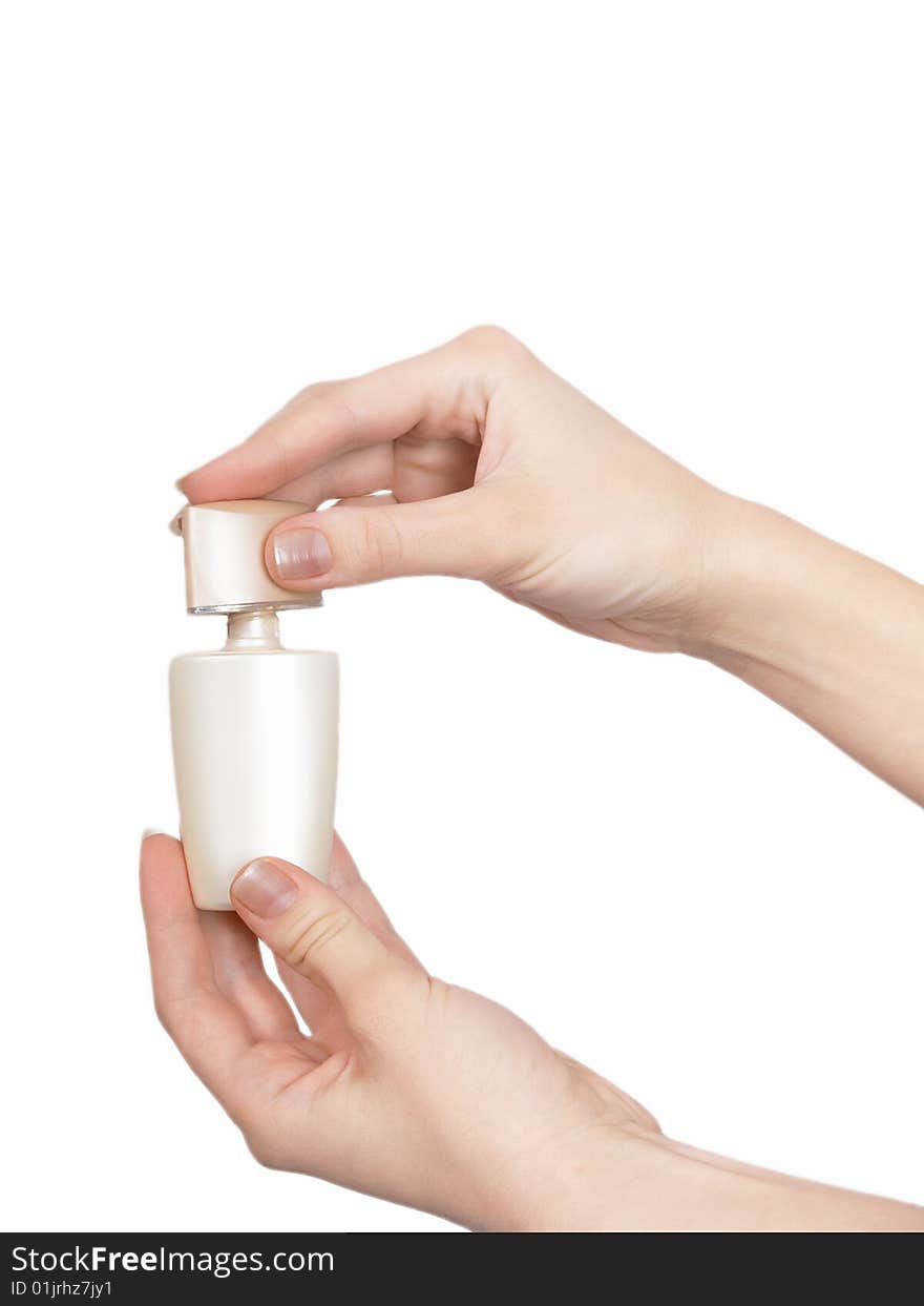 The female hand holds on an open palm a small bottle with perfumery on a white background. The female hand holds on an open palm a small bottle with perfumery on a white background