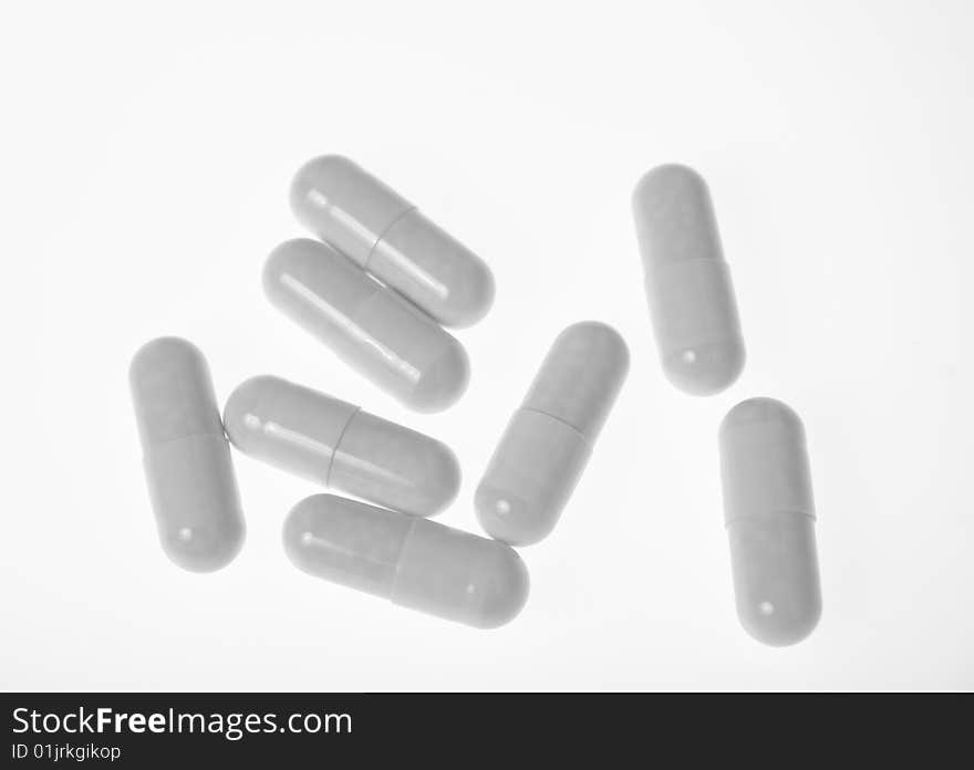 A handful of white pills - capsules on white background