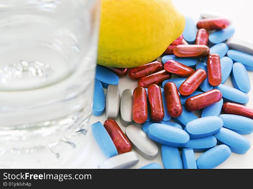 Pills and lemon isolated on white background