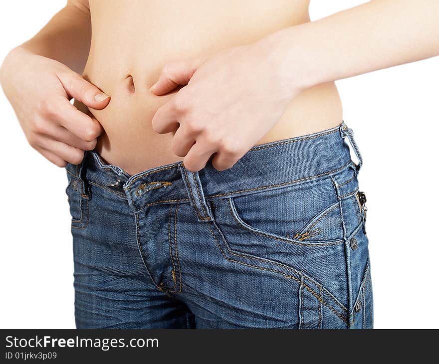 The girl measures the waist  in jeans on a white background. The girl measures the waist  in jeans on a white background