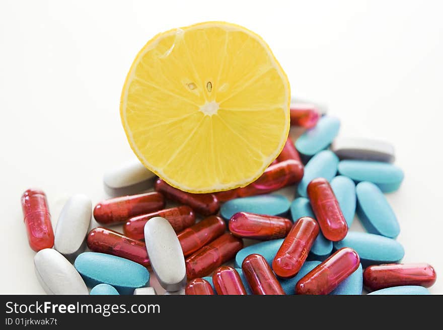 Pills and lemon isolated on white background