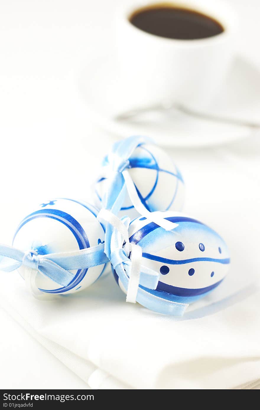 Easter eggs and cup of coffee over white background