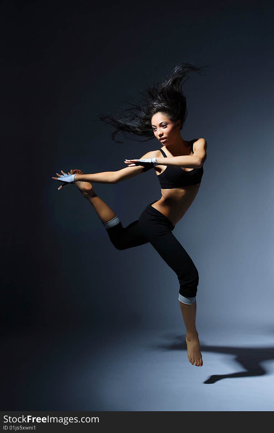 Modern style dancer posing behind studio background