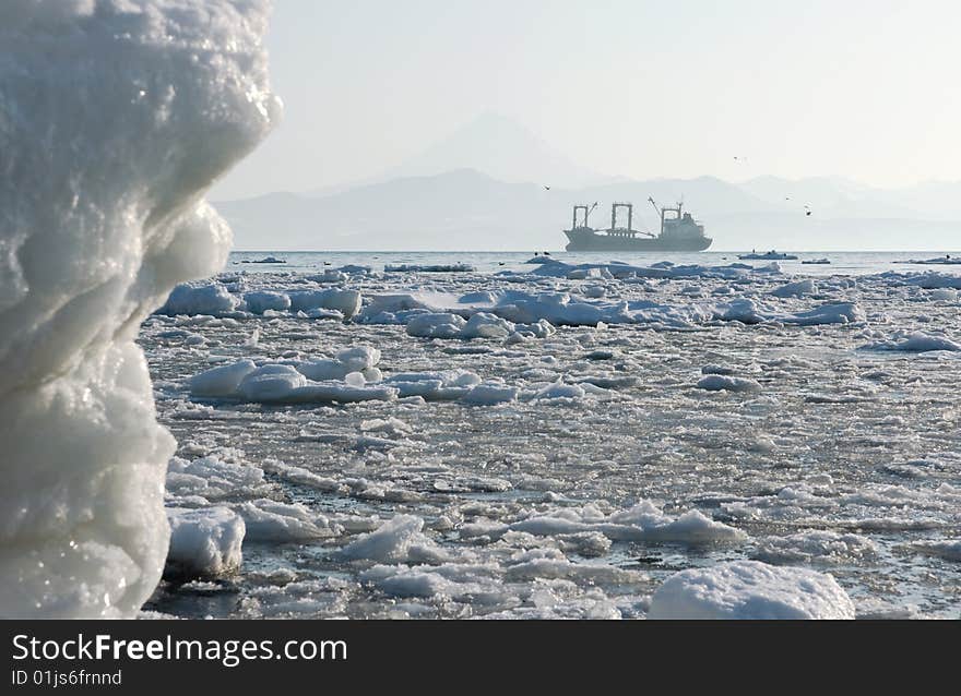 Industrial ship beside coast Kamchatka amongst snow drift ice. Industrial ship beside coast Kamchatka amongst snow drift ice