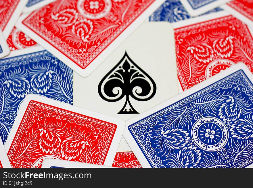 Ace of spades surrounds by red and blue playing cards