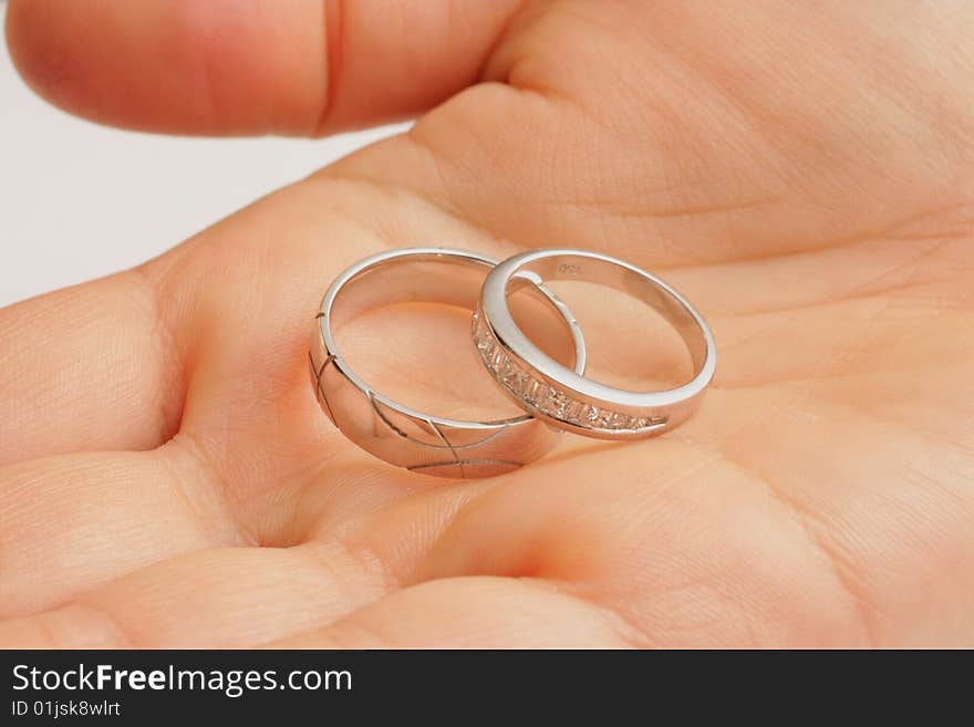 His and Hers wedding rings held in female hand. His and Hers wedding rings held in female hand