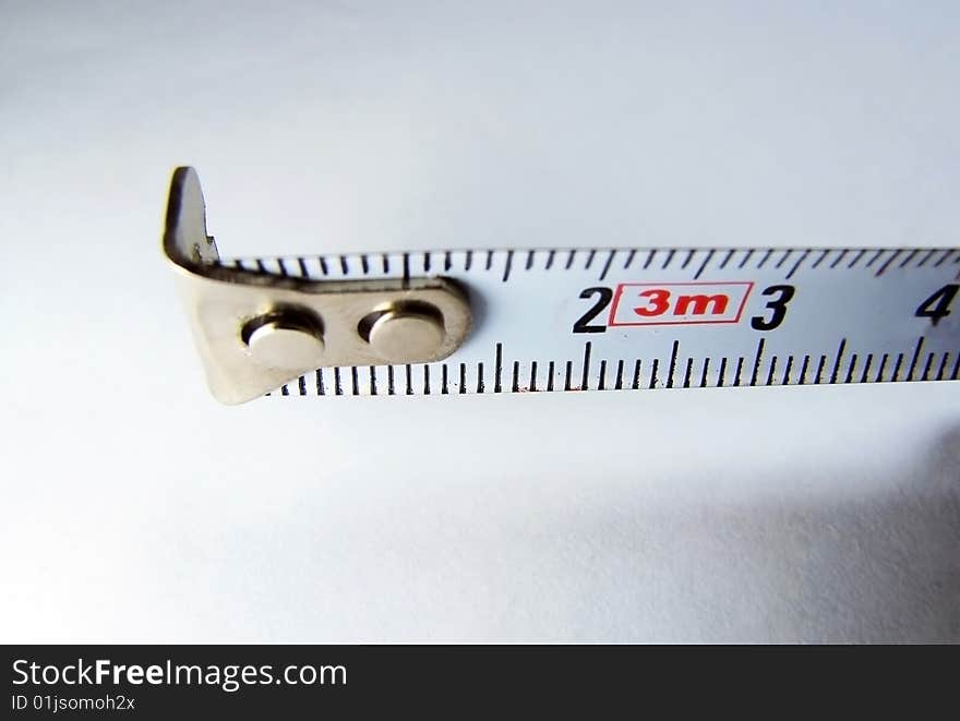 A macro shot of a measure tape against a shadow background. A macro shot of a measure tape against a shadow background.