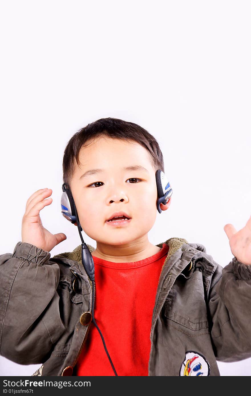 A picture of a little chinese boy listening to music with earphone, having great fun. A picture of a little chinese boy listening to music with earphone, having great fun