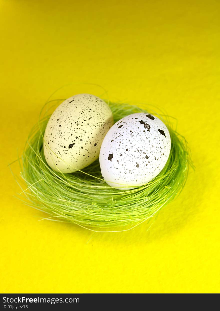 Easter eggs with green nest on yellow paper