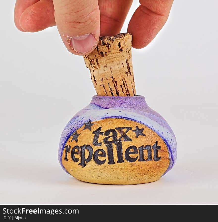 Close-up of hand removing corked bottle labelled, tax repellent. Close-up of hand removing corked bottle labelled, tax repellent