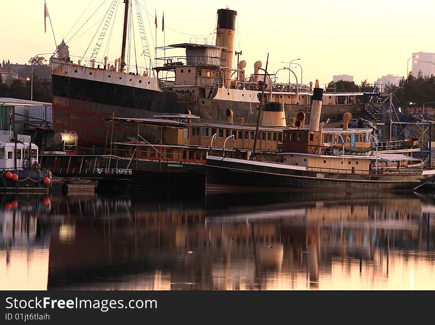 Three old boats on glassy water at dawn. Three old boats on glassy water at dawn.