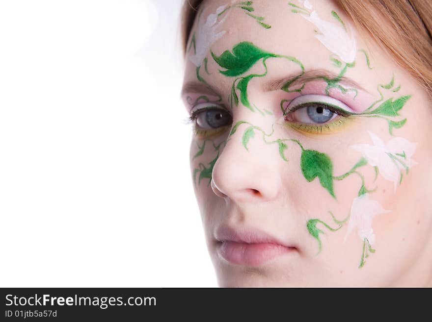 A beautiful young girl with a picture of green flowers on her face. A beautiful young girl with a picture of green flowers on her face