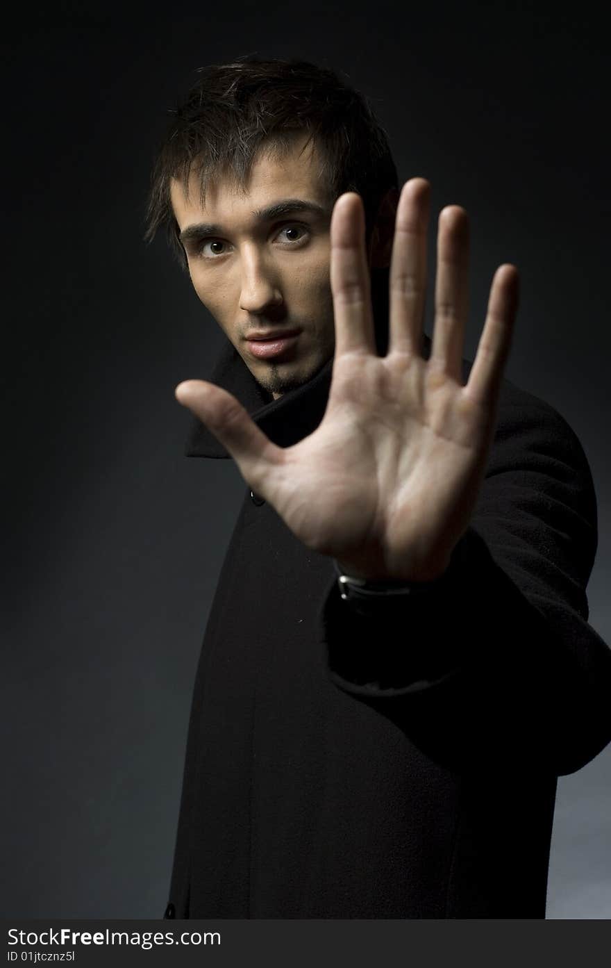 Portrait of a young business man with his hands on a dark background. Portrait of a young business man with his hands on a dark background