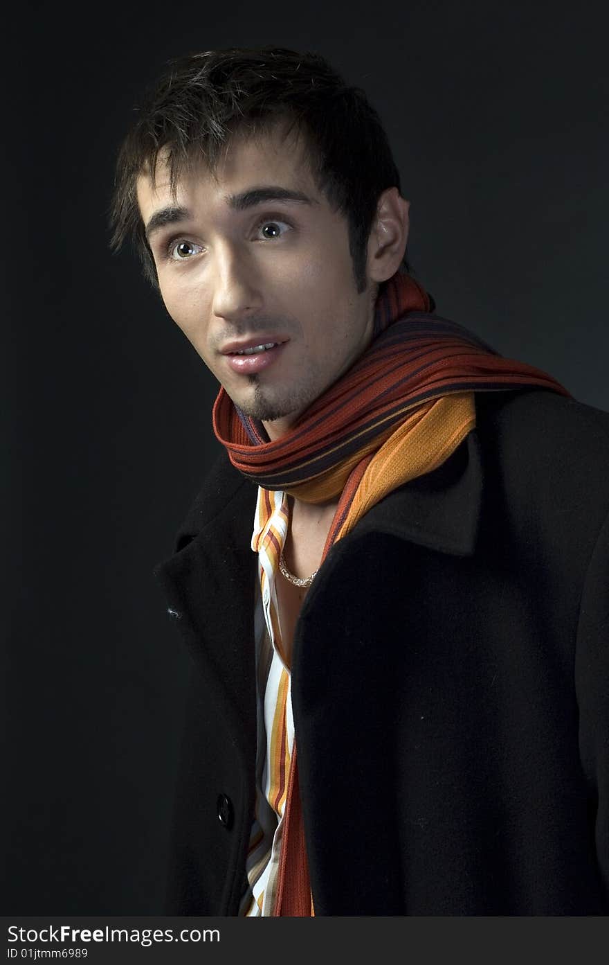 Portrait of a young business man with his hands on a dark background. Portrait of a young business man with his hands on a dark background