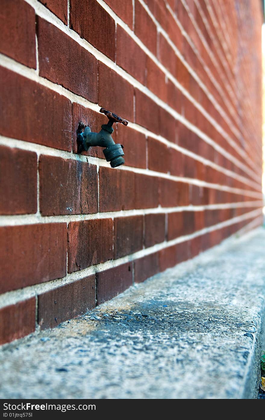 Water faucet on a brick wall