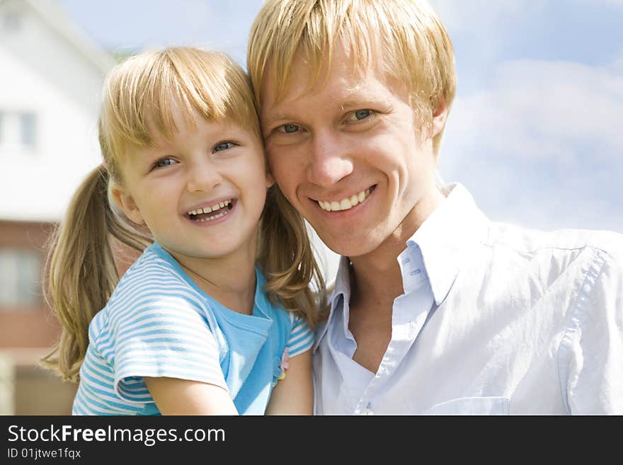 Portrait of happy man with his daughter looking at camera outdoors. Portrait of happy man with his daughter looking at camera outdoors