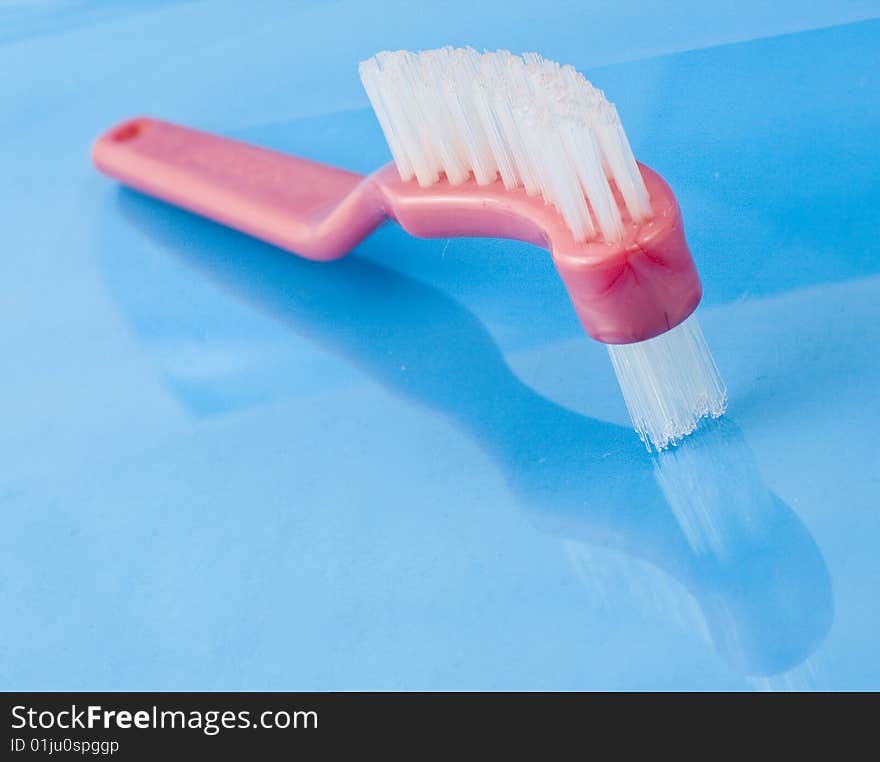 Brush with two fur on the opossite sides isolated on the blue background in up view. Brush with two fur on the opossite sides isolated on the blue background in up view