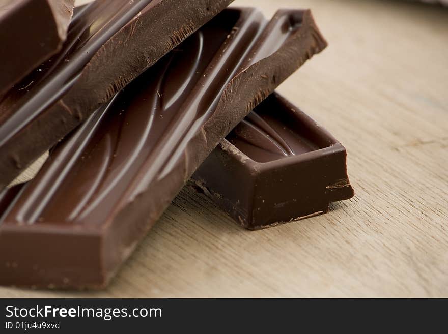 A diagonal composition of chocolate bricks on a wooden background. A diagonal composition of chocolate bricks on a wooden background