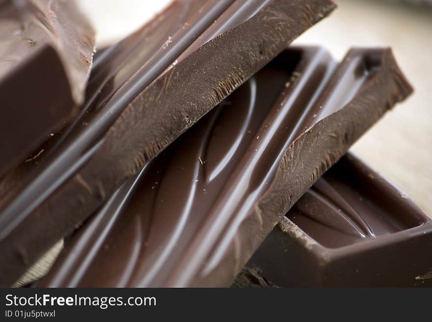 A diagonal composition of chocolate bricks on a wooden background. A diagonal composition of chocolate bricks on a wooden background