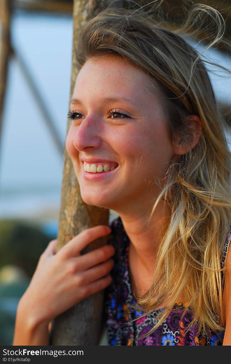 Beautiful young blond girl smiling on beach, showing teeth. Beautiful young blond girl smiling on beach, showing teeth