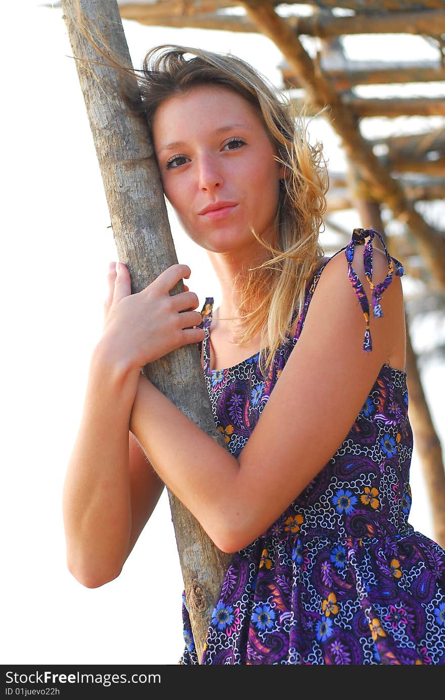 Beautiful smiling young blond girl on the beach holding a pole. Beautiful smiling young blond girl on the beach holding a pole