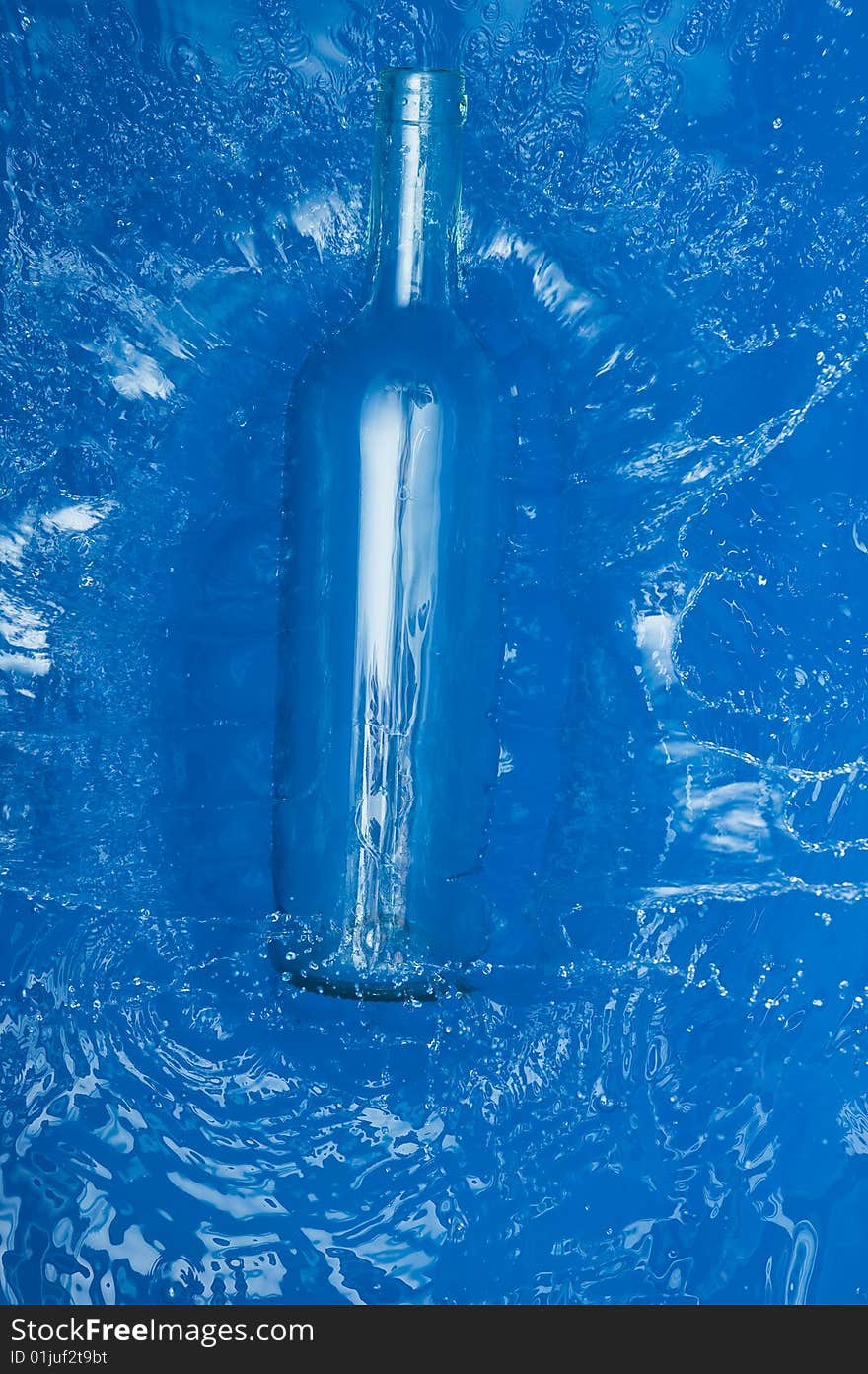 Bottle with splashing water.Blue Background. Bottle with splashing water.Blue Background